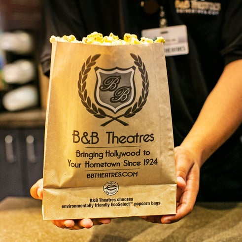 employee handing guest popcorn