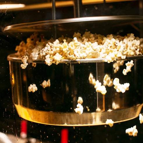 fresh popcorn popping out of kettle