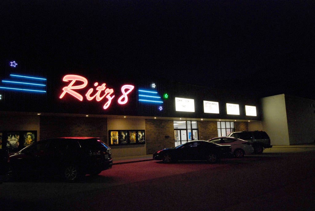 exterior of building at night. Lighted sign reads Ritz 8