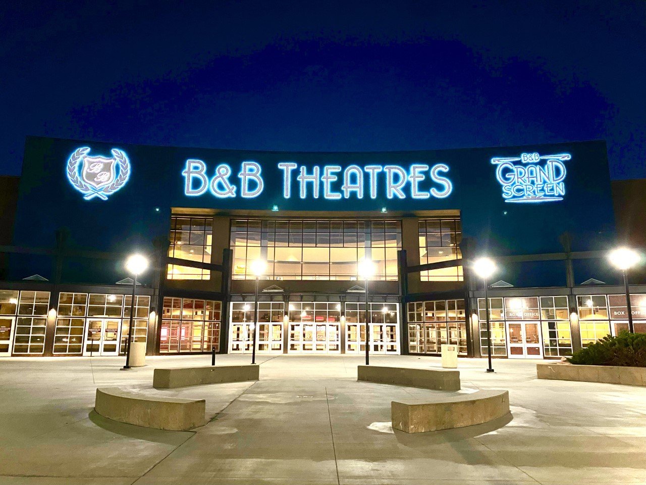 Exterior of building lit up at night. Large B&B Logo, B&B THEATRES, and Grand SCreen logo