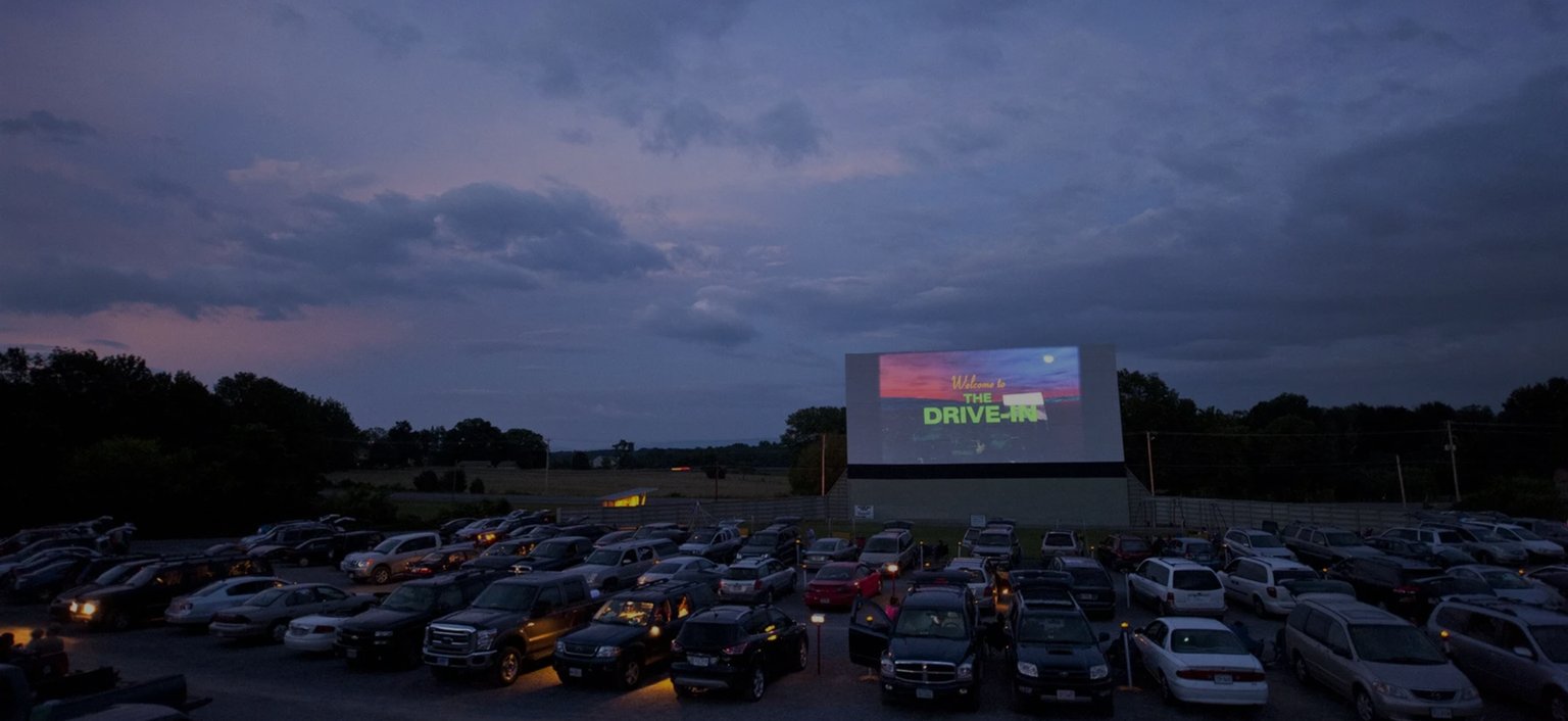 view of the drive in screen and cars parked
