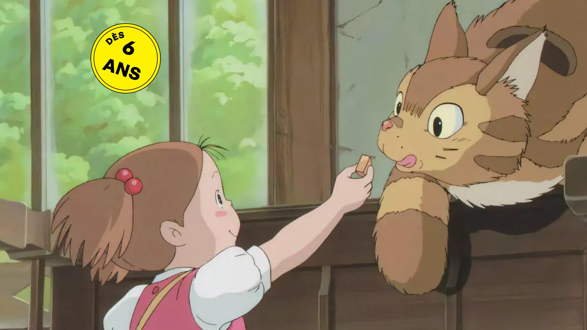 Une petite fille donne à manger à un chat.