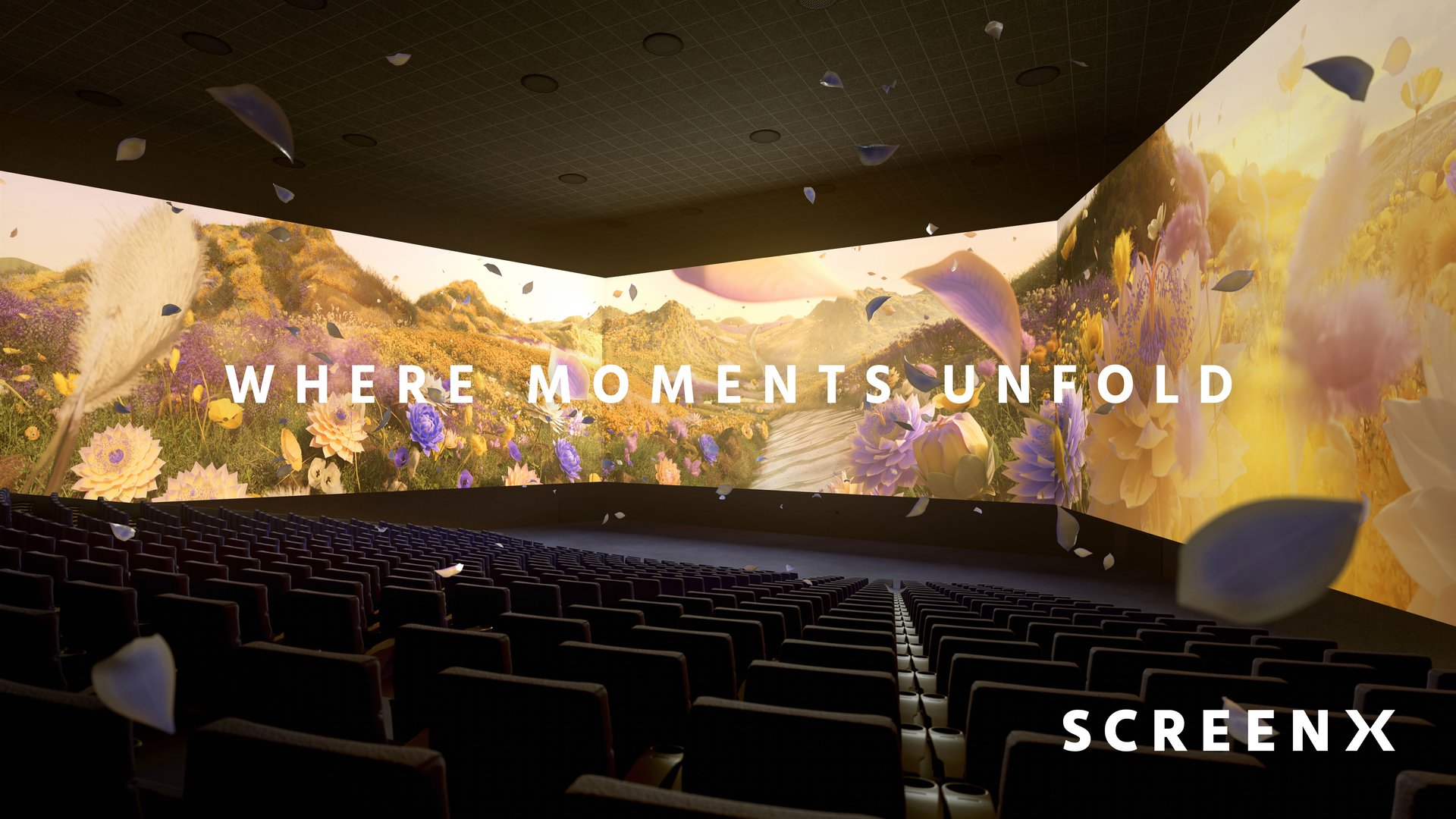 3 walls of screens displaying a field of flowers. petals floating through the auditorium