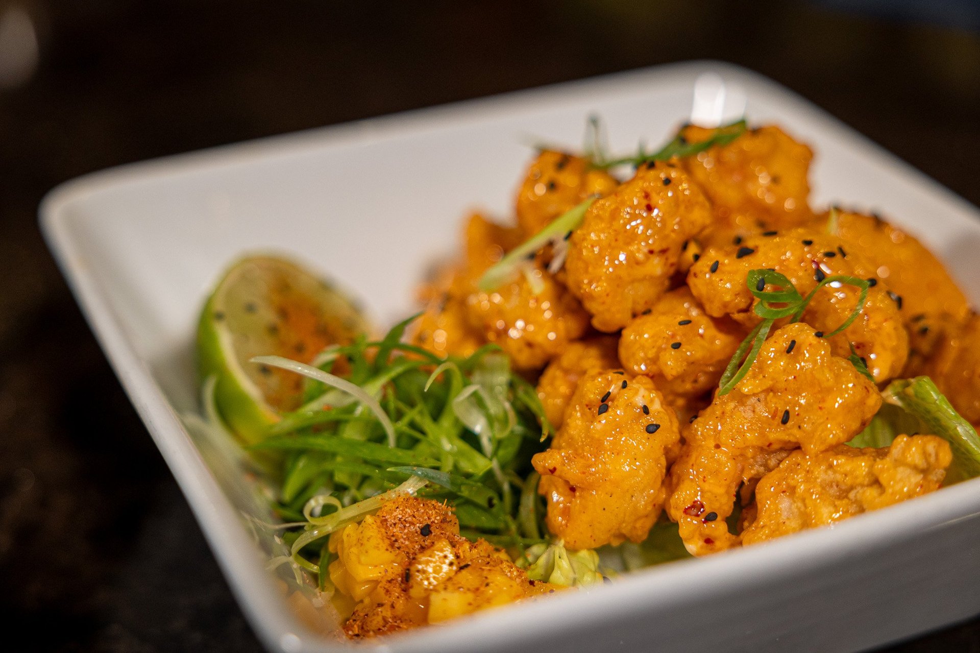 white square bowl filled with rice & bang bang cauliflower bites