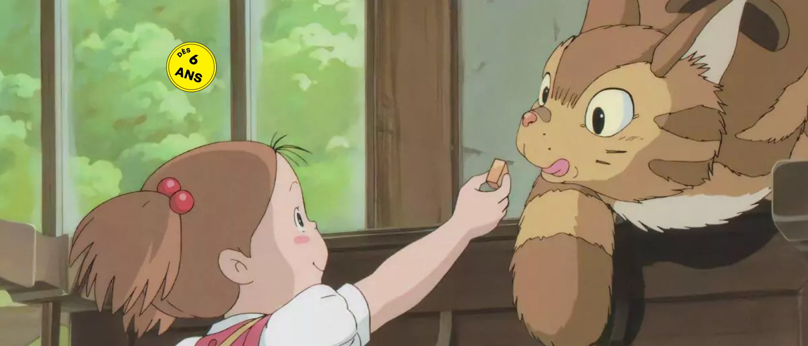 Une petite fille donne à manger à un chat.