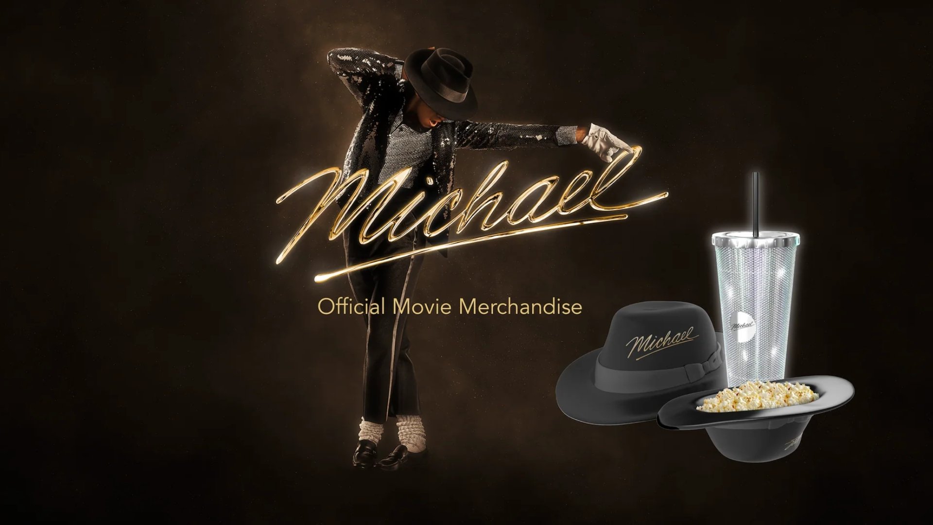 dark background. in the center is michael jackson & the title "Michael" below that reads "Official Movie Merchandise" to the right is a black fedora hat & another turned upside down holding popcorn. Also a silver tumbler cup