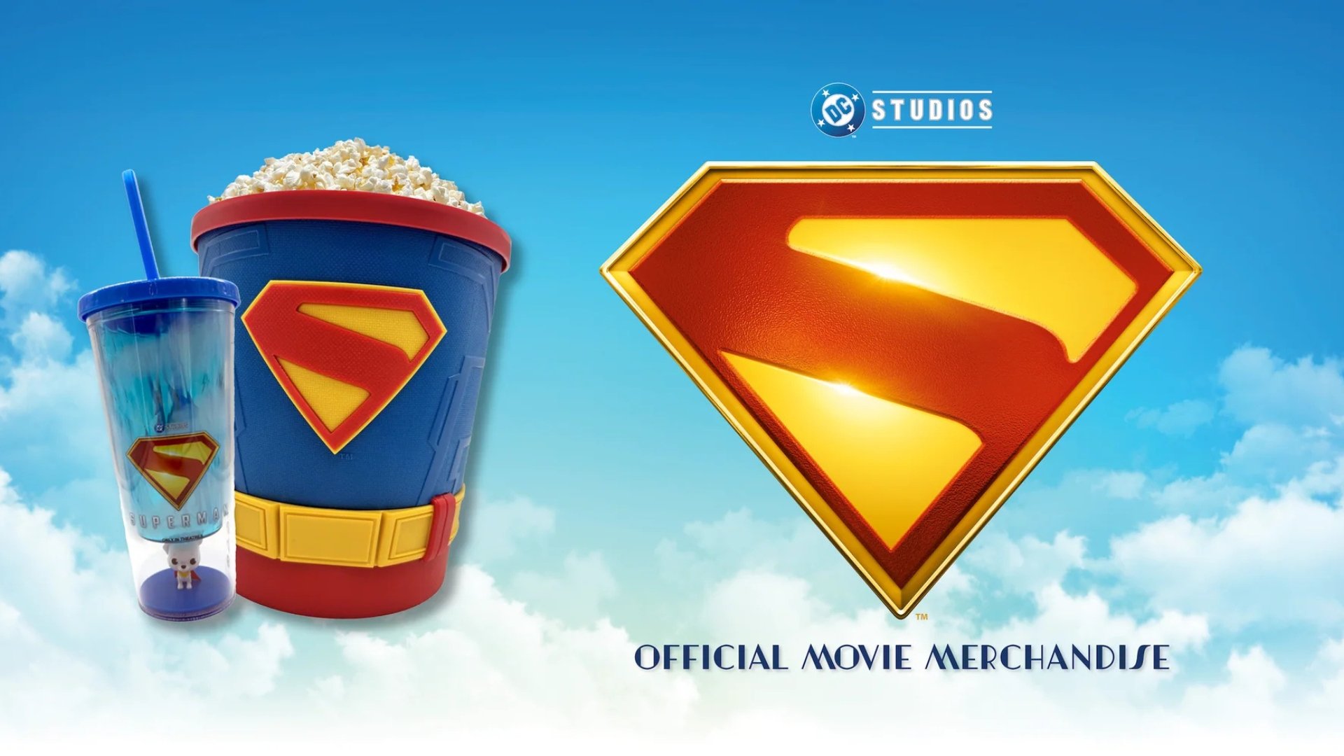 Blue sky background with clouds. Left side features a Superman popcorn tub and a cup. Right side has a giant Superman 'S' logo