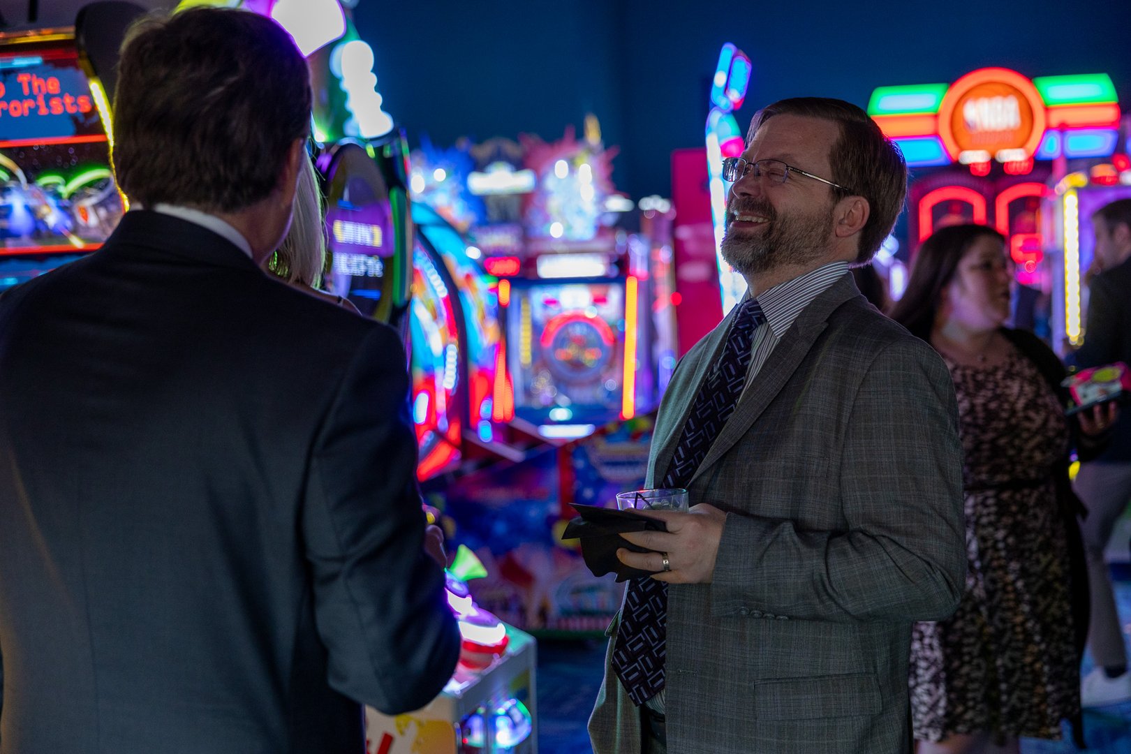 employee smiling and handing a large bag of popcorn to 2 guests.