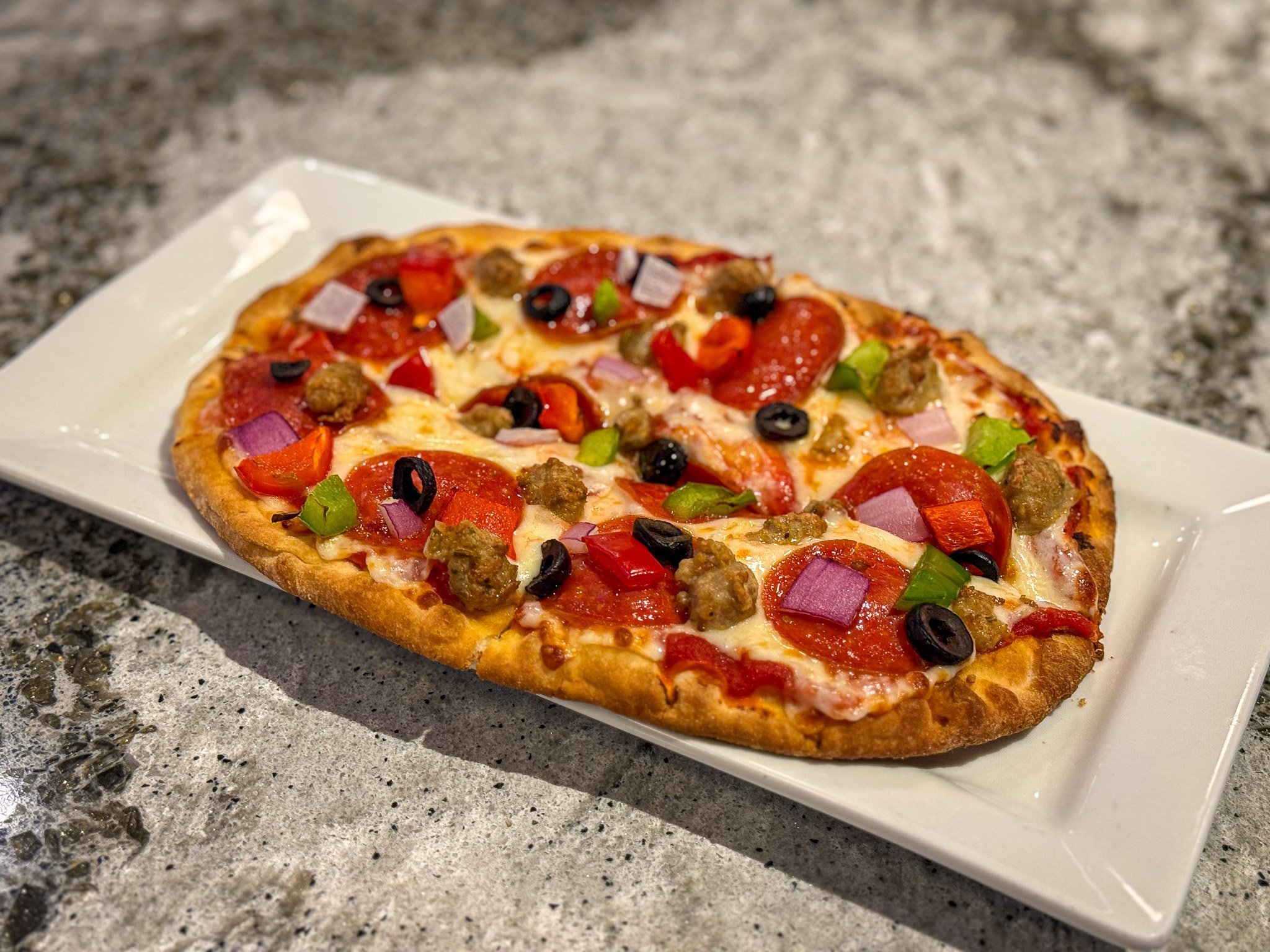 the works flatbread pizza: including pepperoni, sausage, peppers, onions, black olives