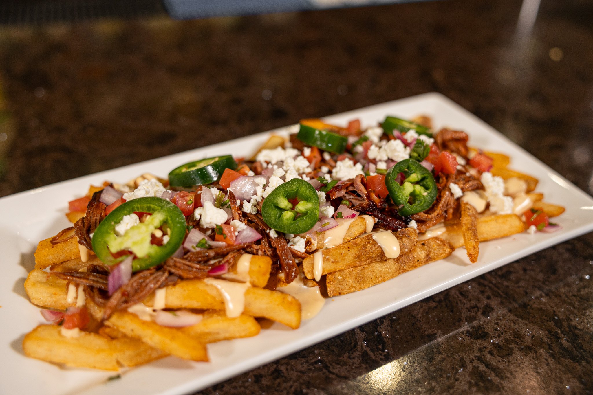 loaded fries topped with tomatoes and jalapenos