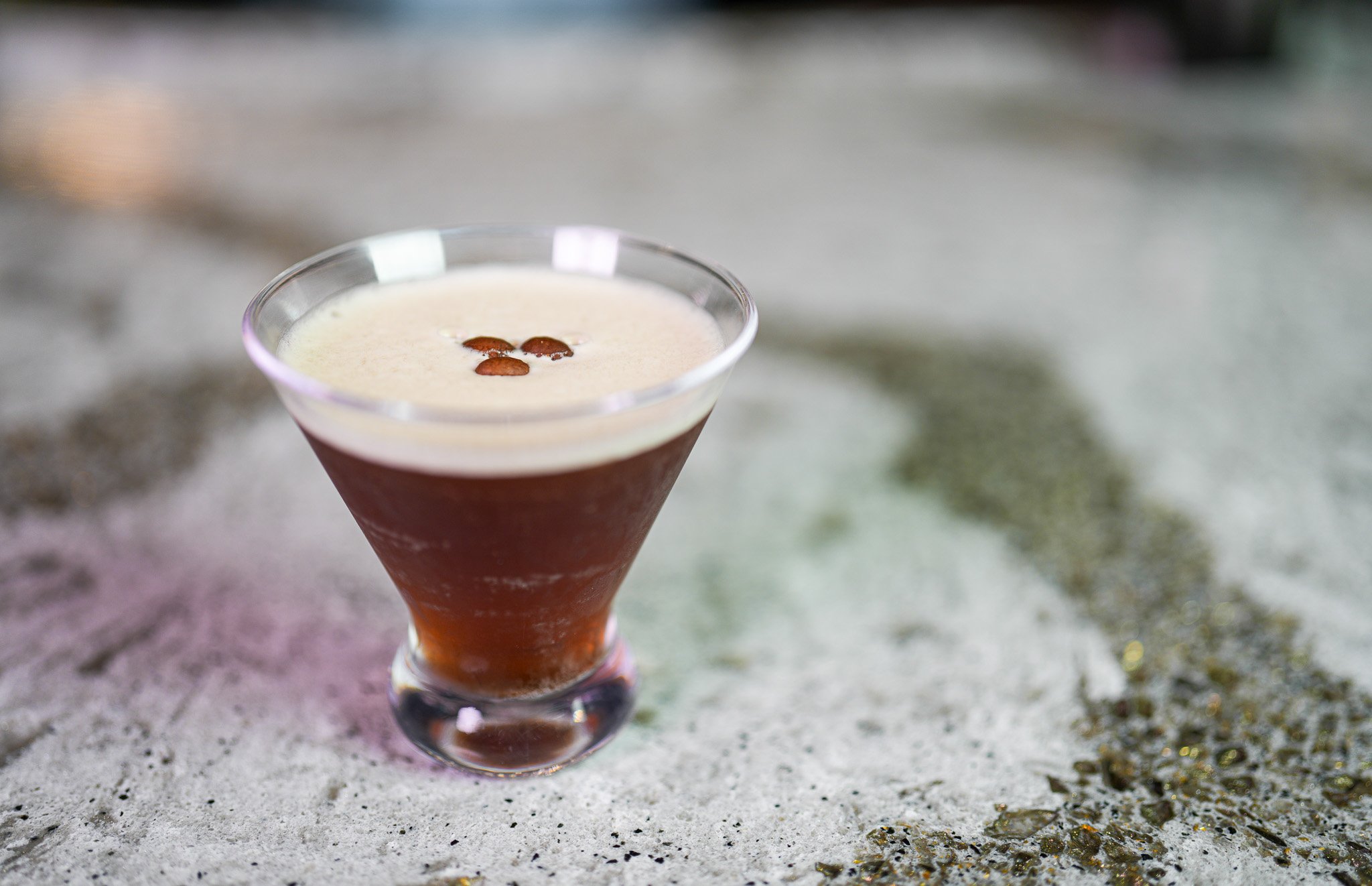 short martini glass with an espresso martini topped with 3 espresso beans