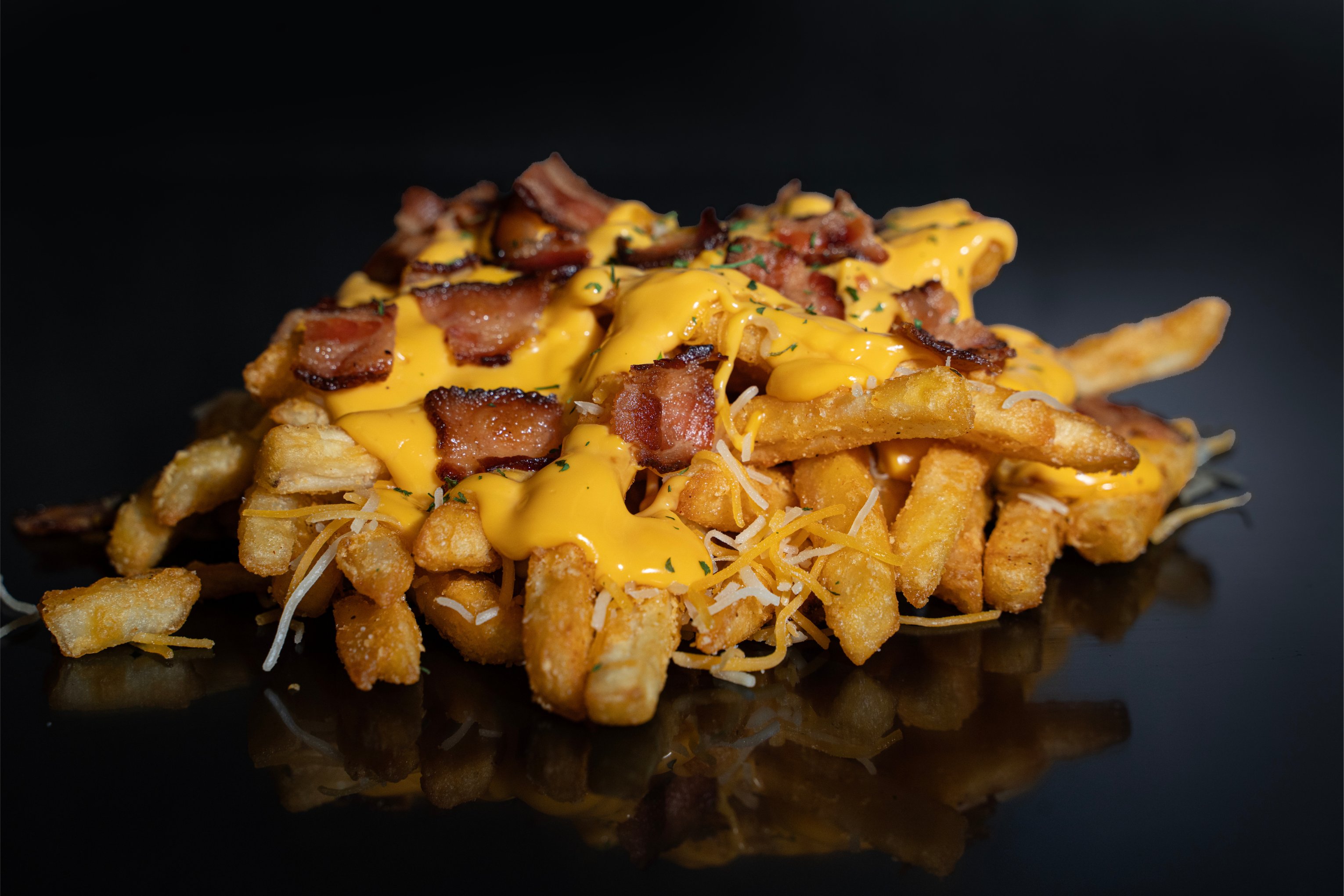 loaded fries with nacho cheese, bacon pieces, shredded cheese