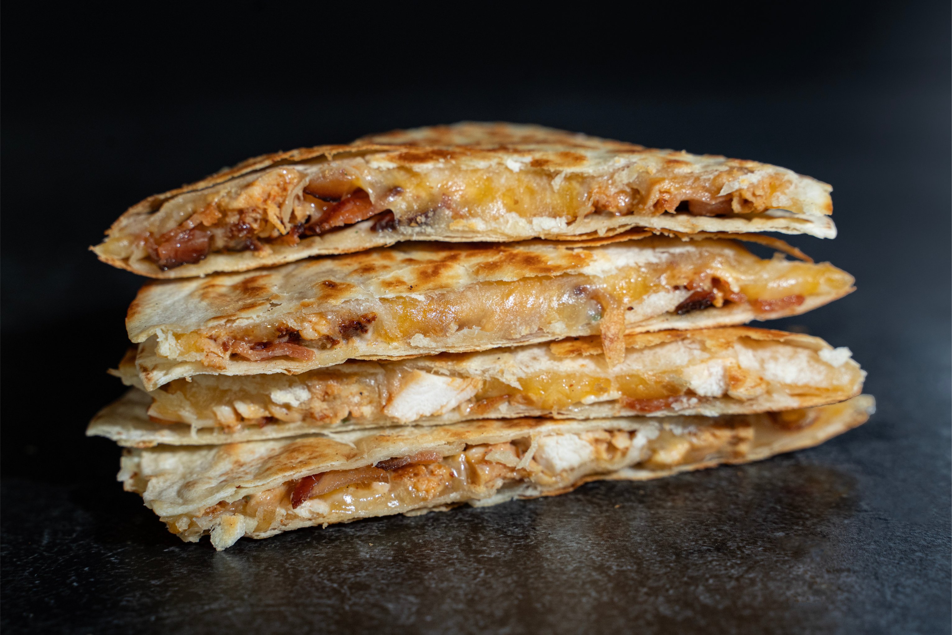 4 slices of chicken bacon ranch quesadilla stacked on top of each other