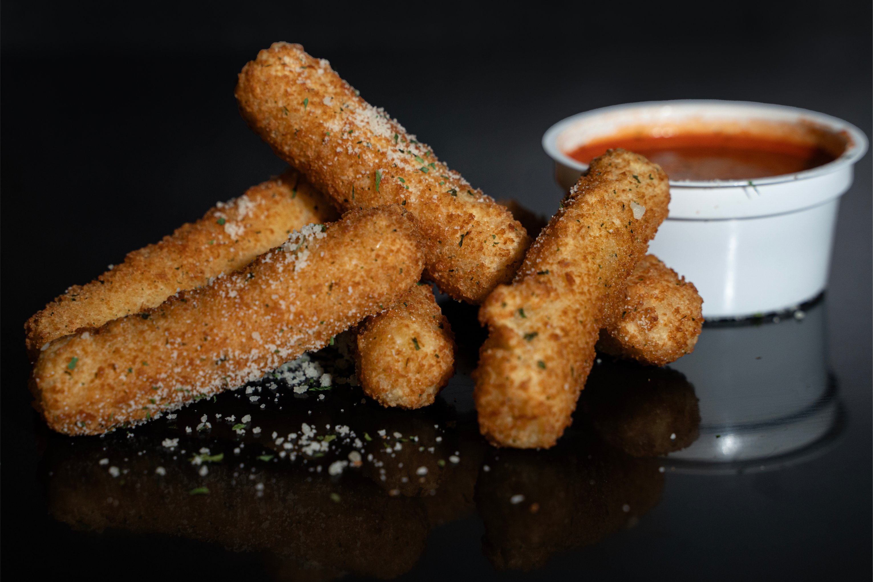 mozarella sticks with marinara cup in the background