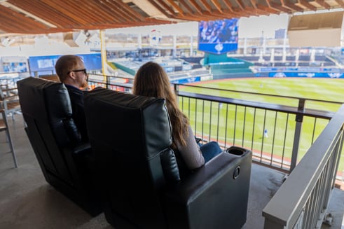 two guests sitting in black recliners at Kauffman stadium