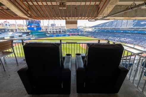 the back of two black recliner chairs facing the field at Kauffman Stadium