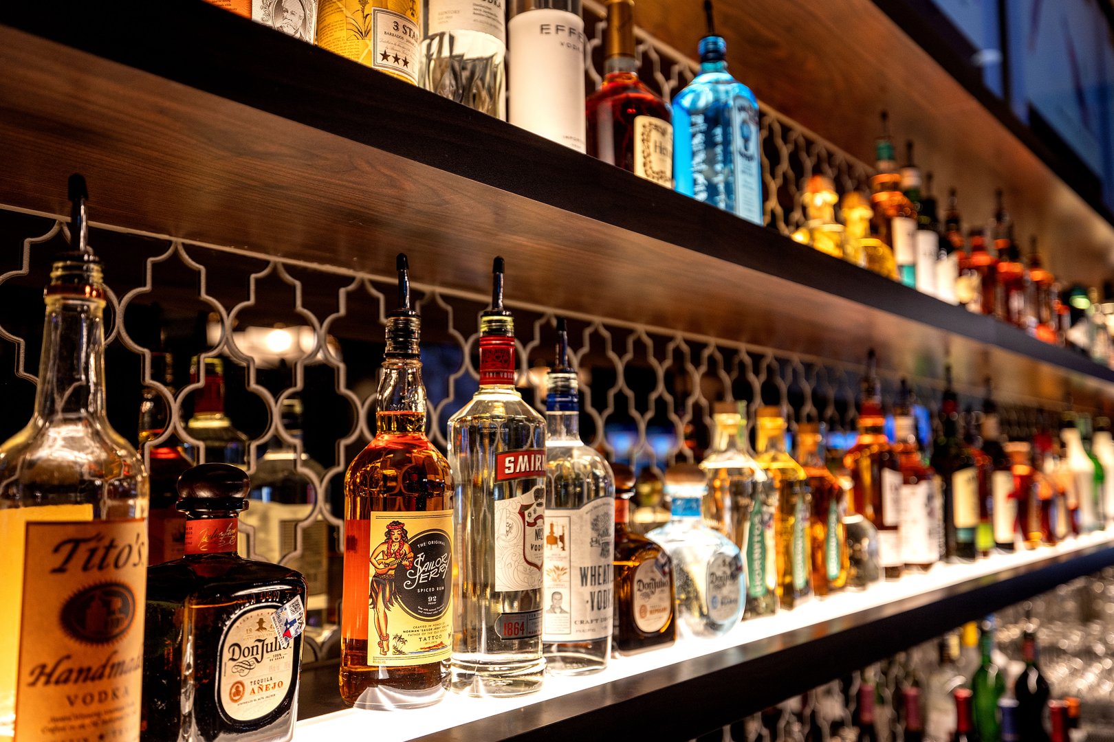 angled image of rows of liquor lined up behind the bar