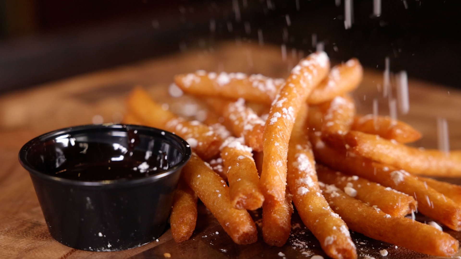 wood butcher block background.4 diagonally sliced southwest eggrolls fanned out sitting on leaves of lettuce. small white square container of ranch sitting behind the egg rolls.
