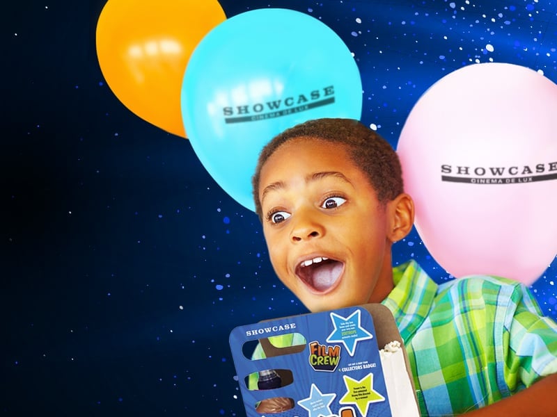 a child holding a party box with balloons behind them